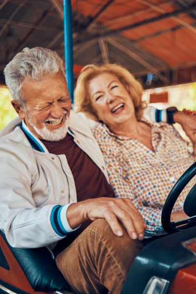 mature couple riding in bumper cars